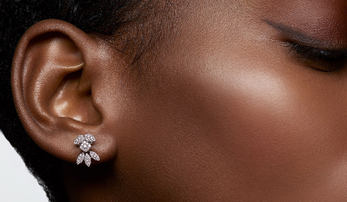 A woman wearing Birks Snowflake diamond earrings.